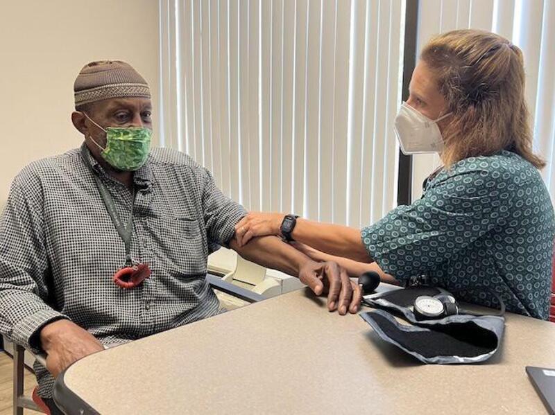 A woman sitting next to a man with her hands touching his right arm. 