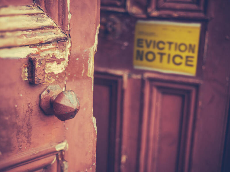 A front door to a home with a sign saying \"Eviction Notice.\"