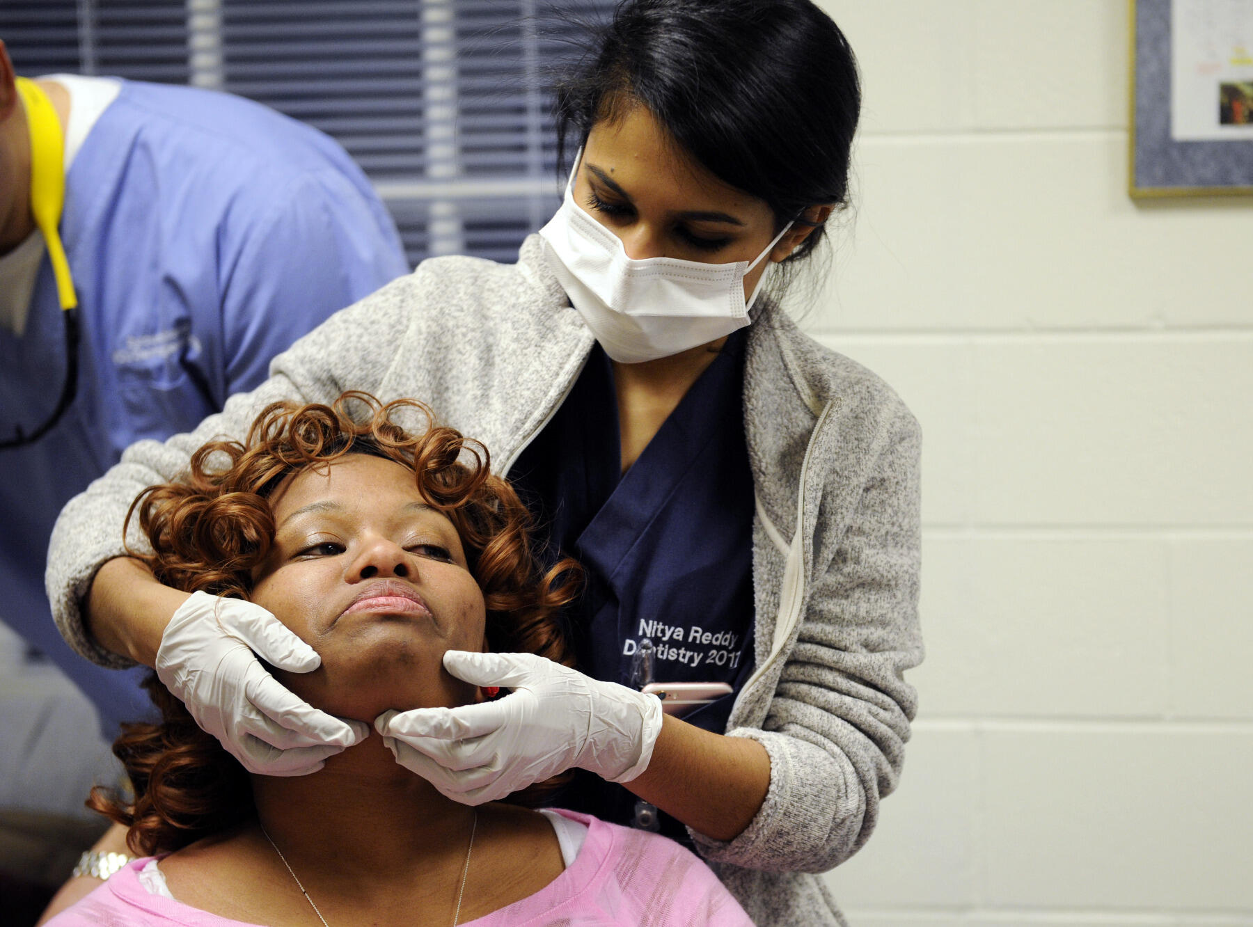 Fourth-year doctor of dental surgery student Nitya Reddy does an oral health screening on CARITAS resident Fabienne Ismael. Ismael works part time at McDonalds, but does not make enough money to afford rent. "I have to pay for my ride to and from work because there is no bus that goes there," Ismael said. "I have a phone bill to pay. I don't have money after that."
