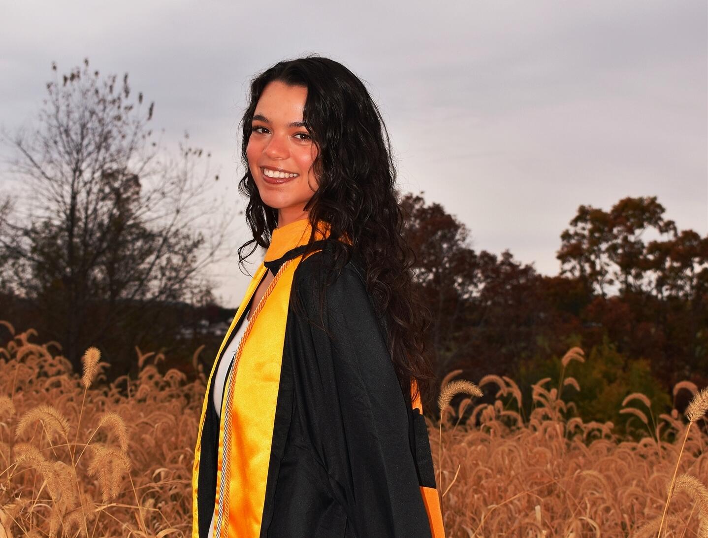 A photo of a woman wearing a graduation cap and gown