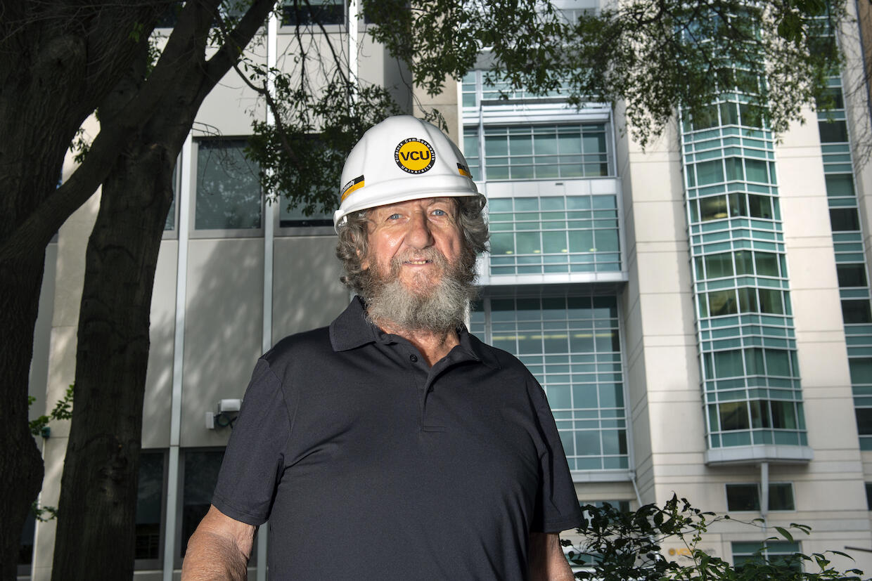 Jimmy Pollock wearing a hard hat with a V C U logo on the front.