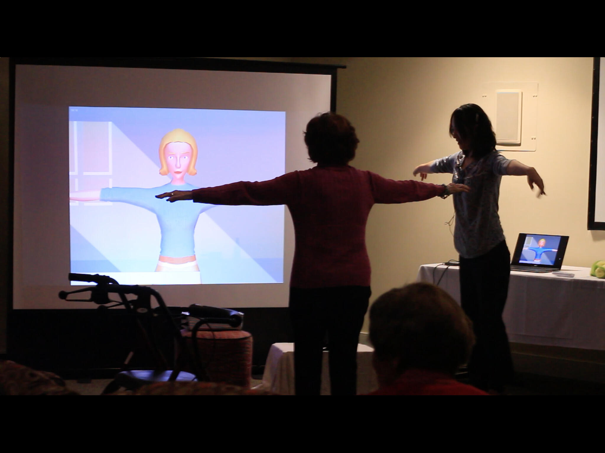 VCUarts Associate Professor Semi Ryu, right, demonstrates how the on-screen avatar mimics the user’s motions.  
