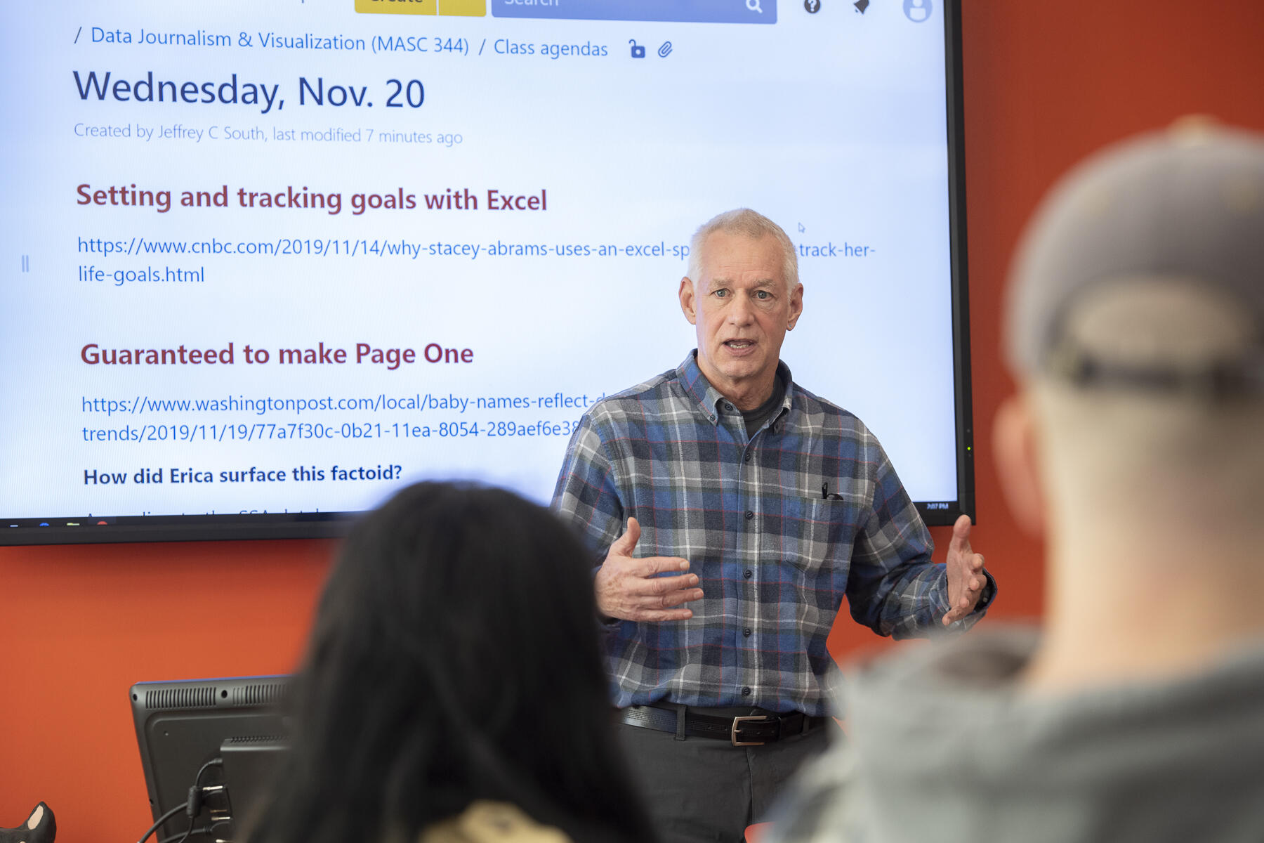 A professor speaks to a class of students.
