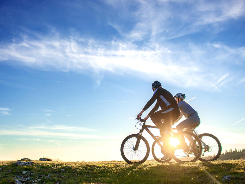 A photo of a man and a woman on two bikes next to each other 