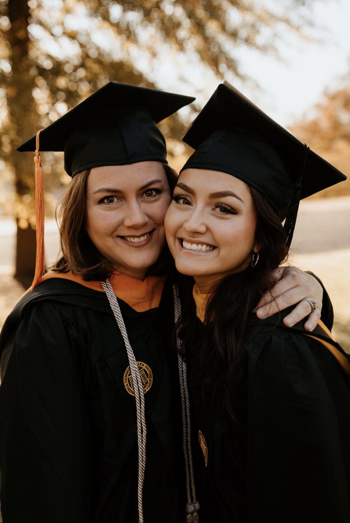 Two women wearing graduation cap and gowns