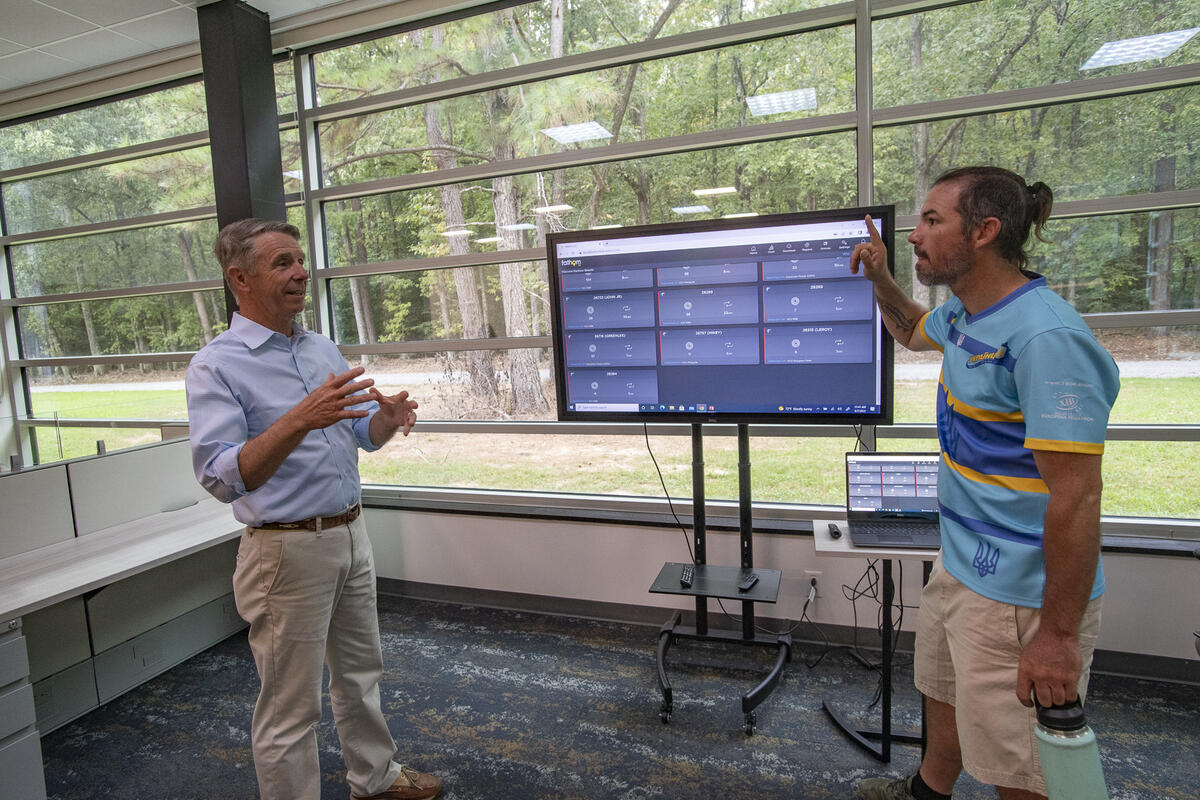 Two men standing in between a screen 