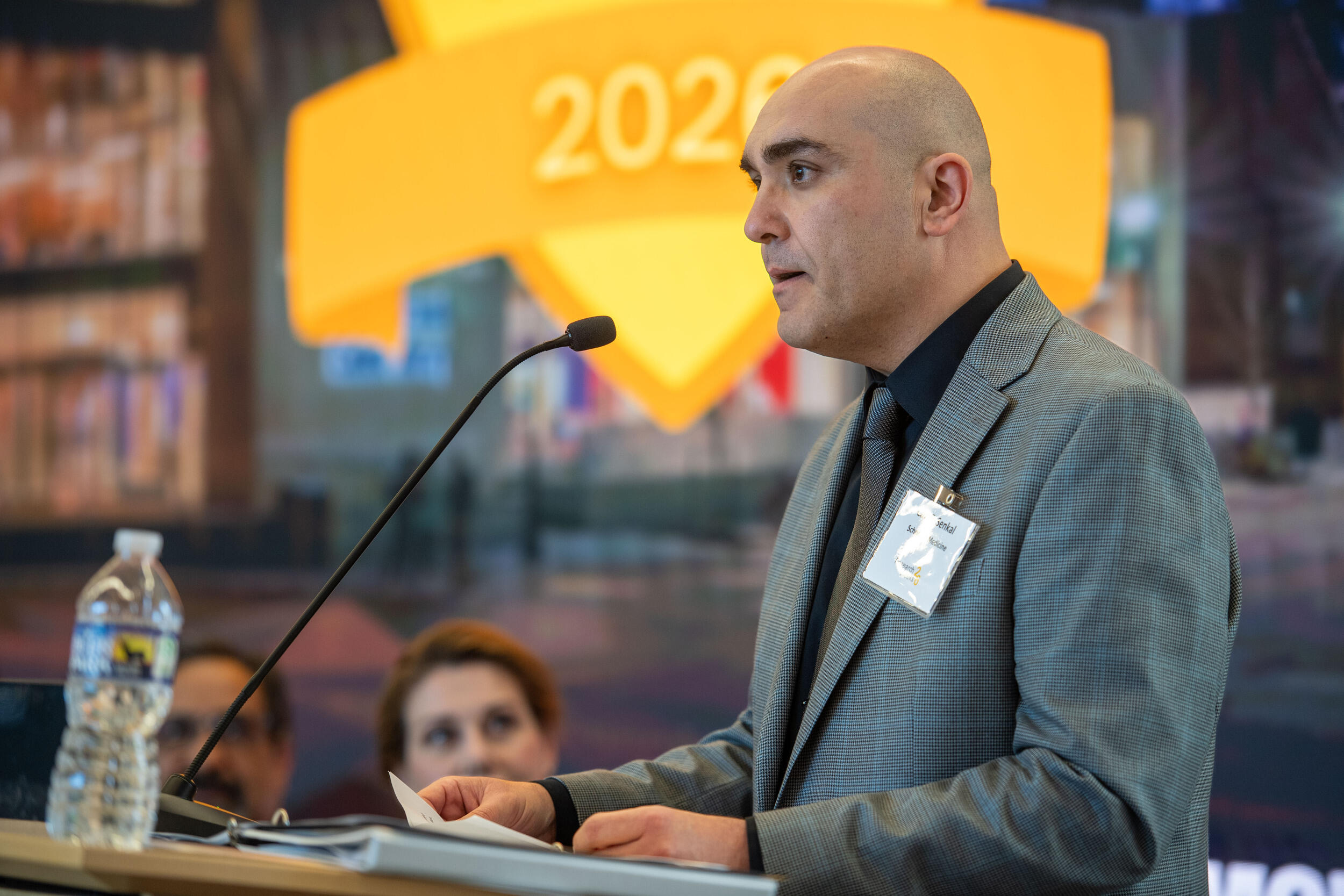 A photo of a man standing behind a podium. 