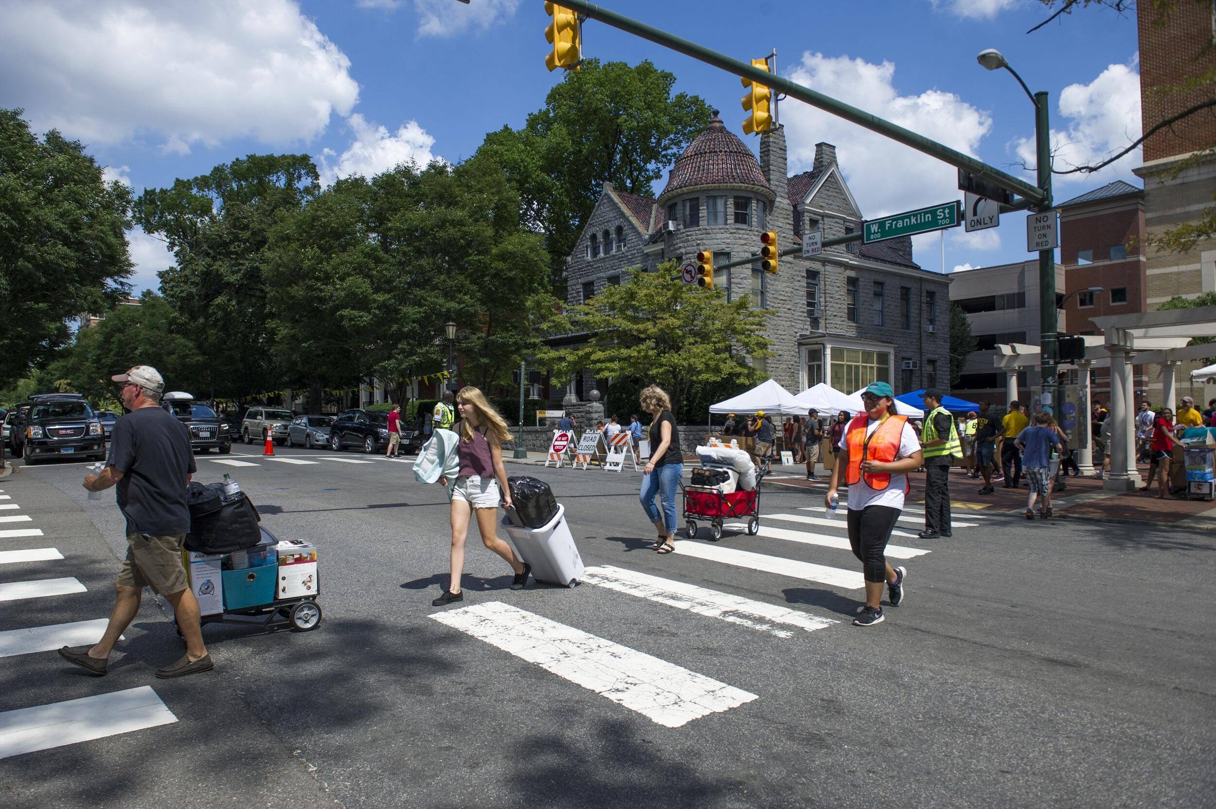 People walking across Franklin street with boxes on carts