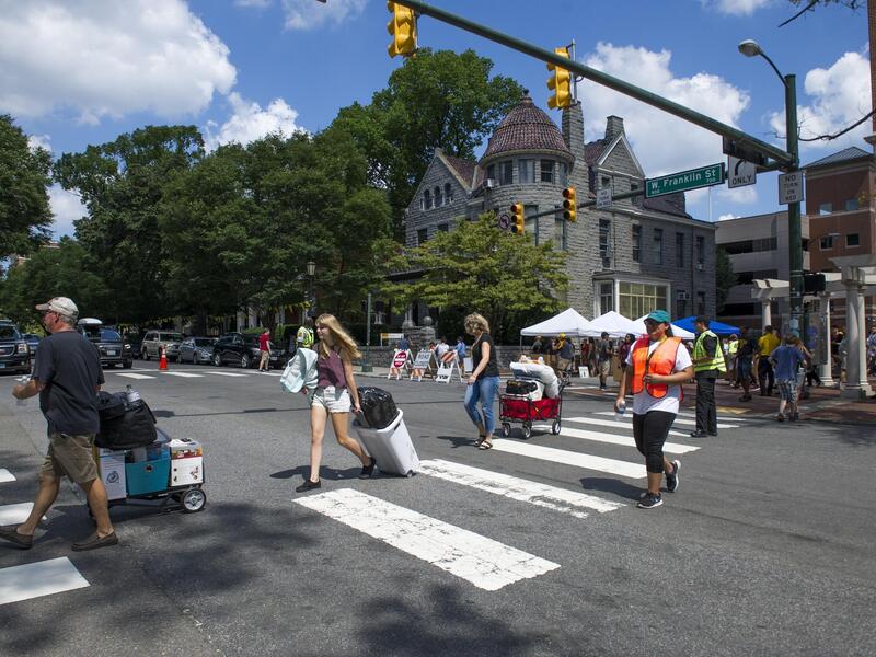 People walking across Franklin street with boxes on carts