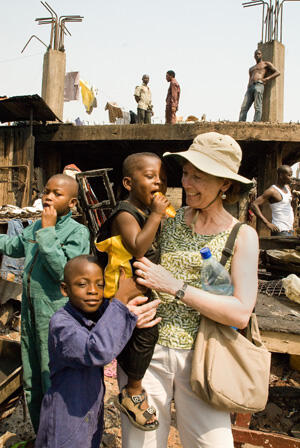 Randi Buerlein, M.S.W., assistant director of field instruction for the VCU School of Social Work, walks through the slum area of Accra with three brothers, two of whom have recently been selected for sponsorship to attend school, thanks to the success of the VCU’s FOR AFRICA benefit performance in November.  Photo by Doug Buerlein.  