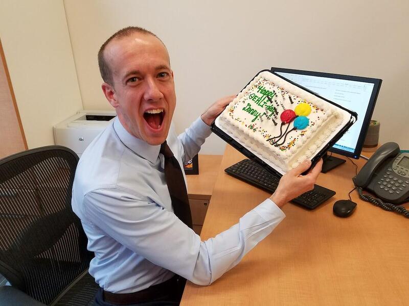 Danny Woodward holding a cake.