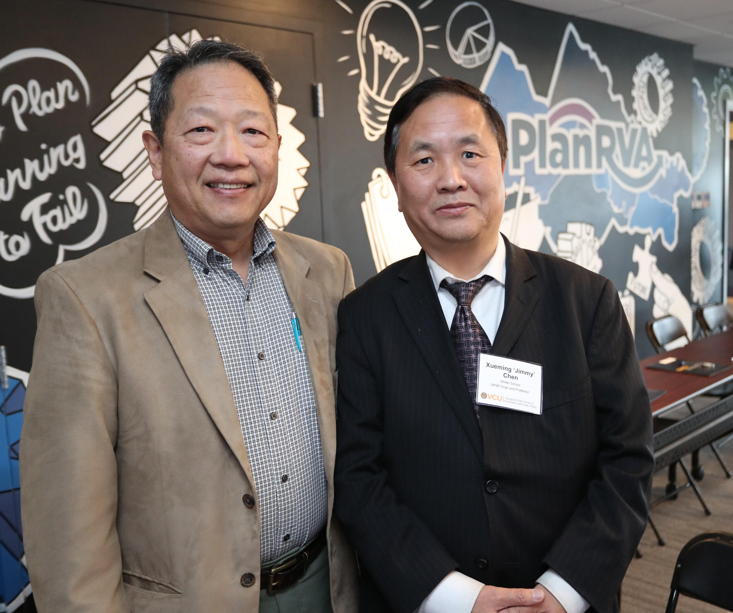 Two men in sports coats standing together and facing the camera.