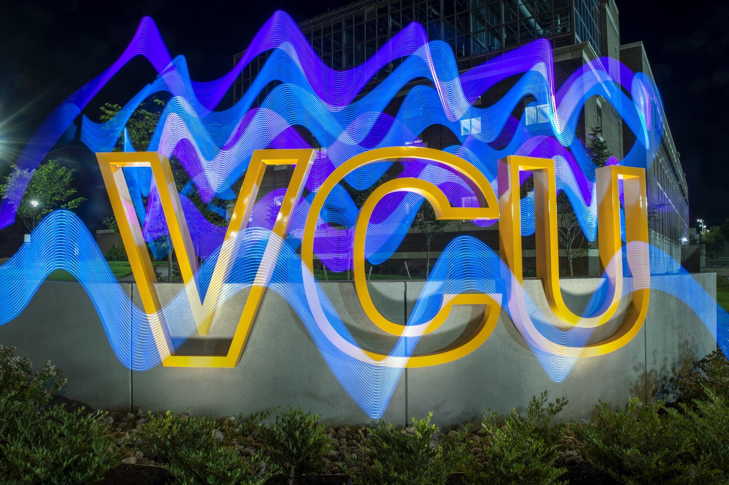 Yellow letters that spell \"V-C-U\" with blue wavy lines over them 