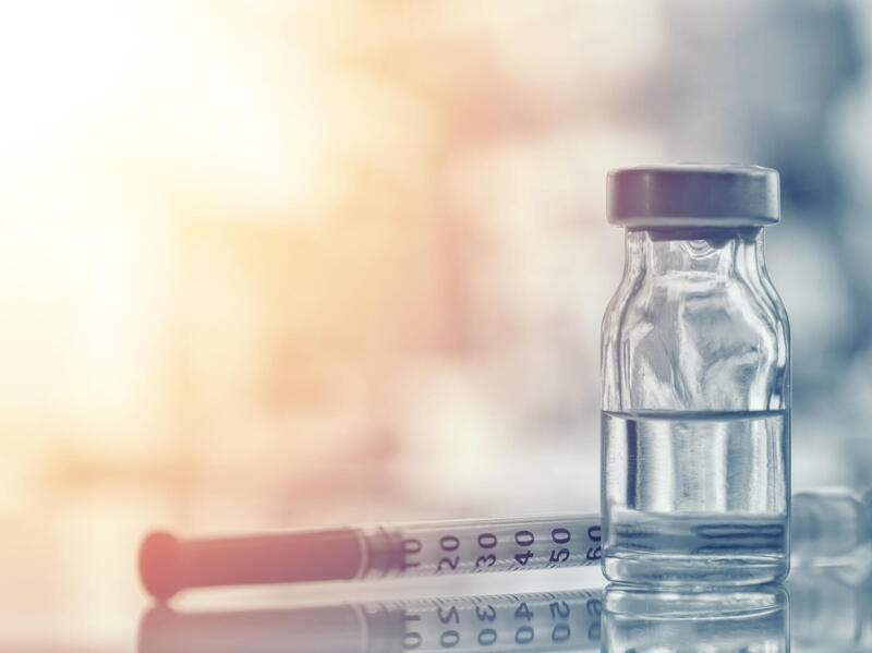 A hypodermic needle and a vial of medication.