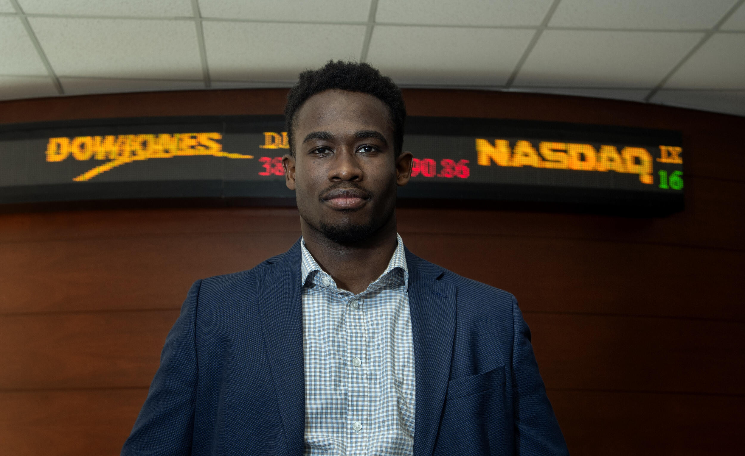 A photo of a man wearing a suit jacket and button down shirt from the chest up. 