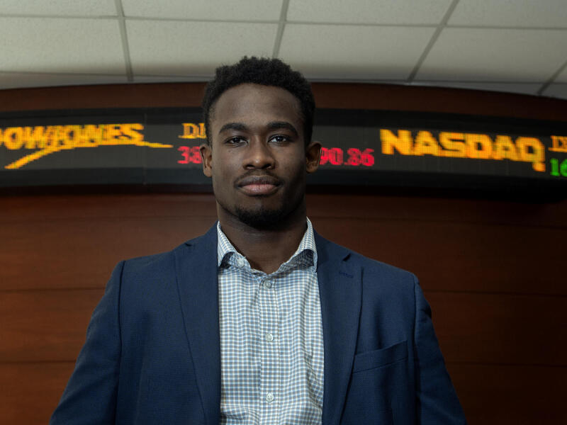 A photo of a man wearing a suit jacket and button down shirt from the chest up. 