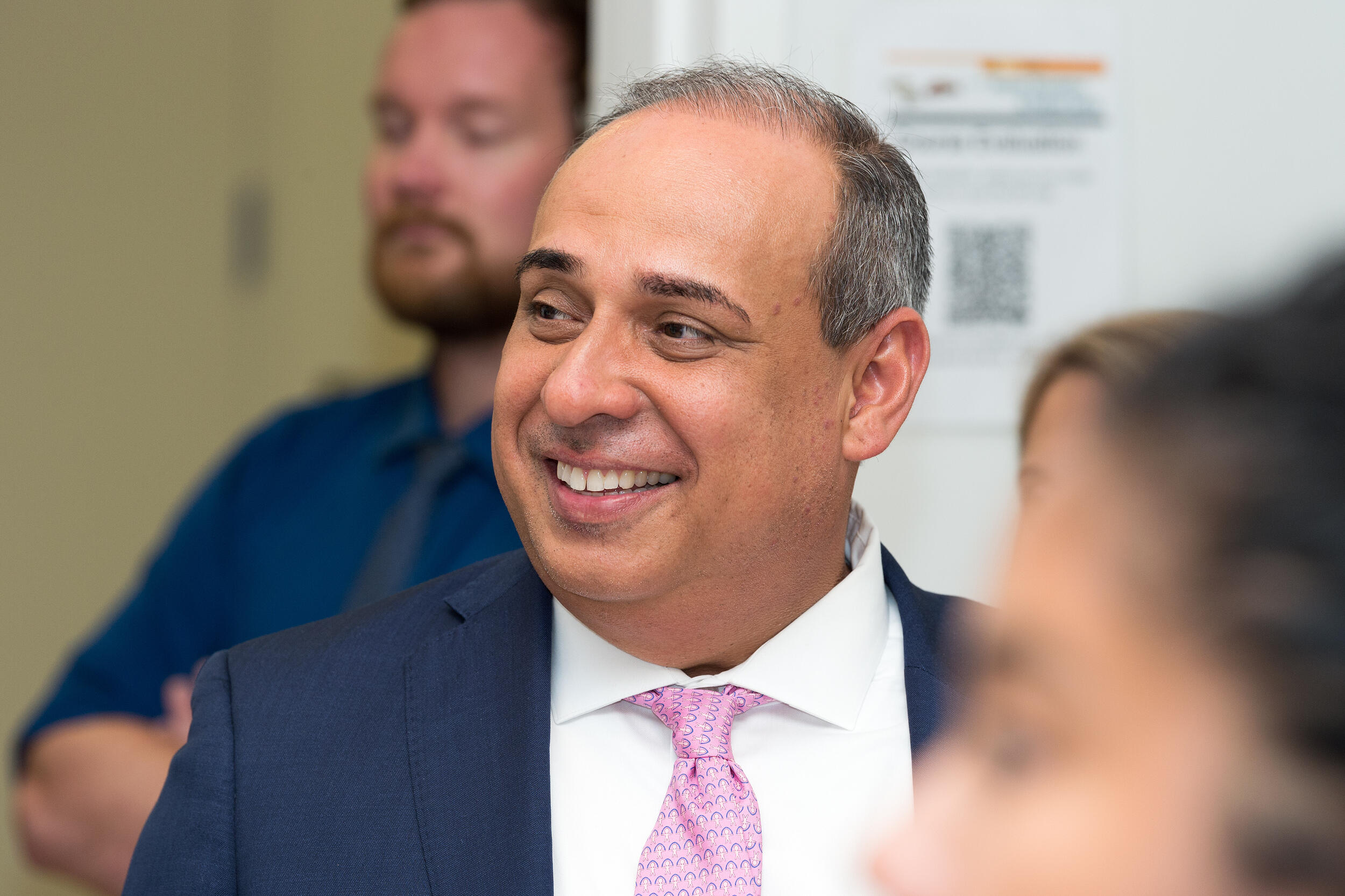 A phot of a man smiling and looking to the left 