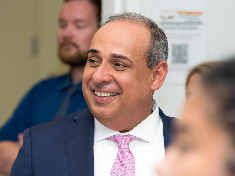 A phot of a man smiling and looking to the left 