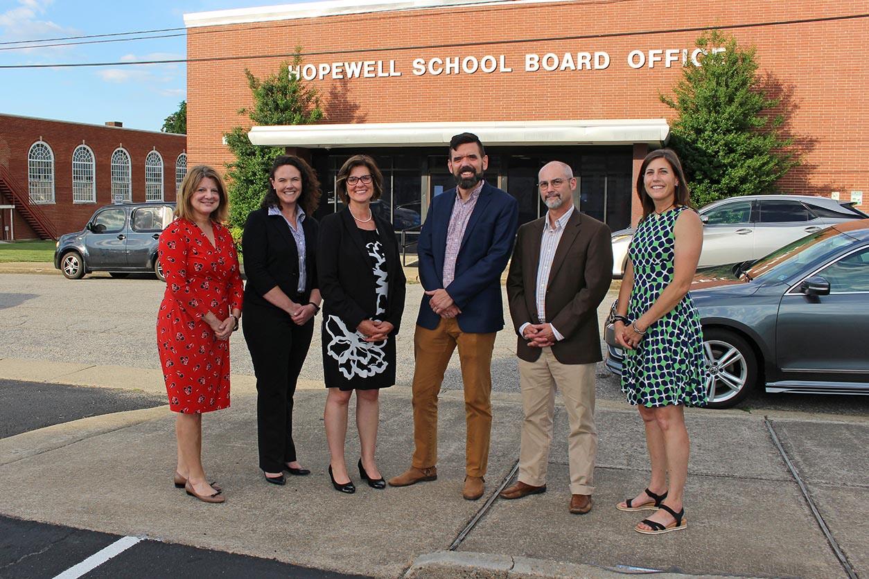 A group of five people standing in front of the Hopewell School Board Office