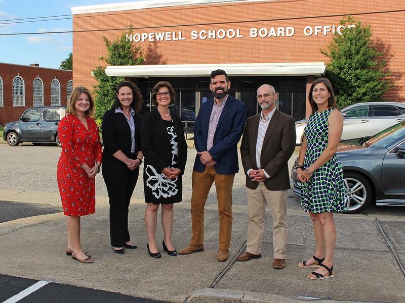 A group of five people standing in front of the Hopewell School Board Office