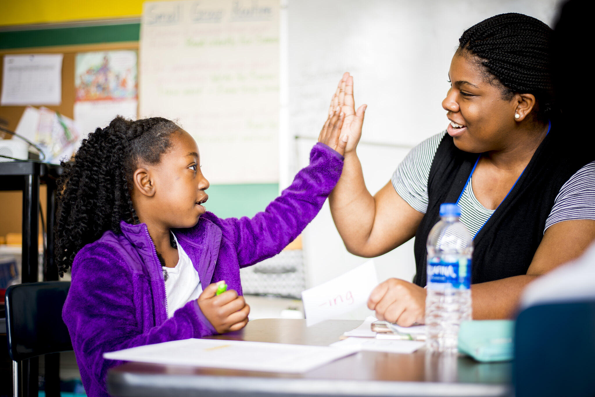 A child high fiving a woman 