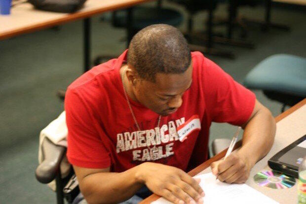 Calvin Cropper Jr. sitting at a desk completing his schoolwork.
