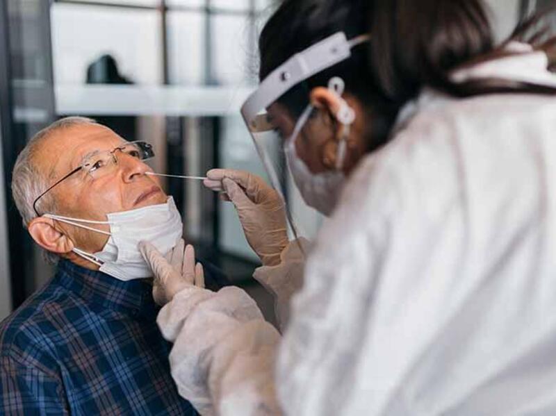 A pharmacist administers a COVID test
