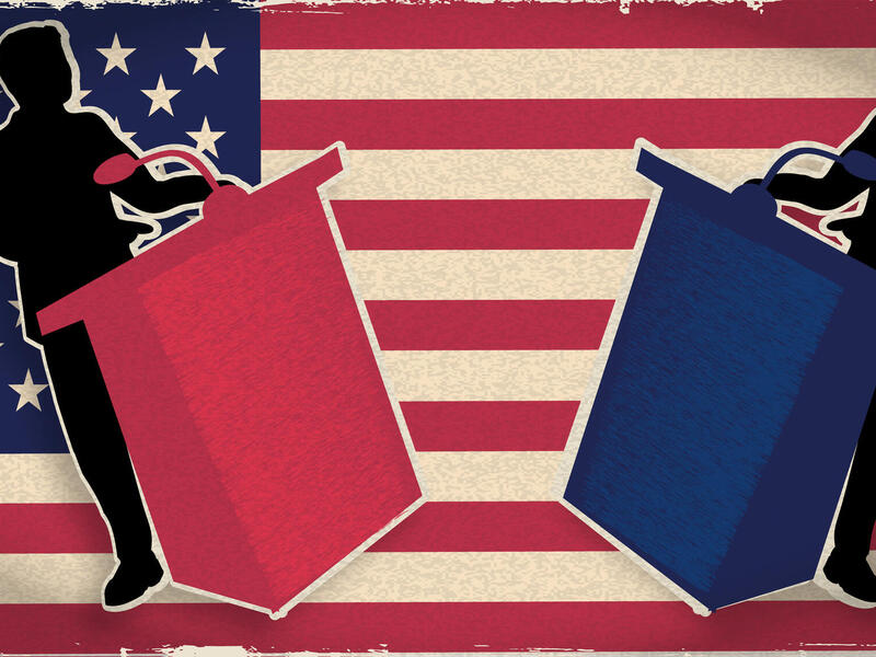 An illustration of the silhouette of two men standing behind podiums. Both men are black, but the podium on the left is red and the podium on the right is blue. Behind the men is a large American flag. 