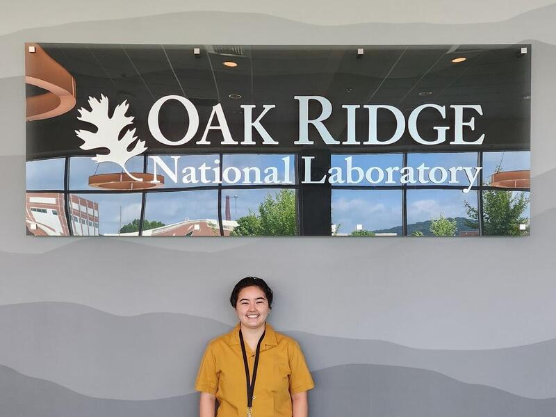 A photo of a person standing in front of a sign that says \"Oak Ridge\"