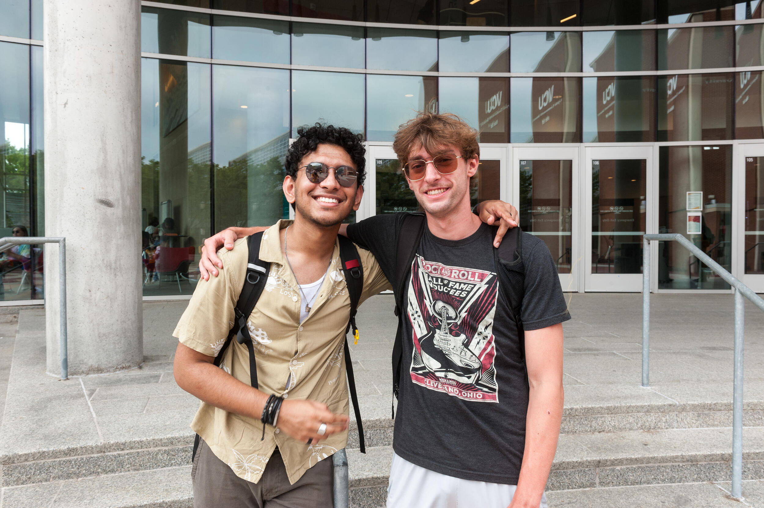 Two men standing next to eachtoher with one arm across the other's shoulder. 