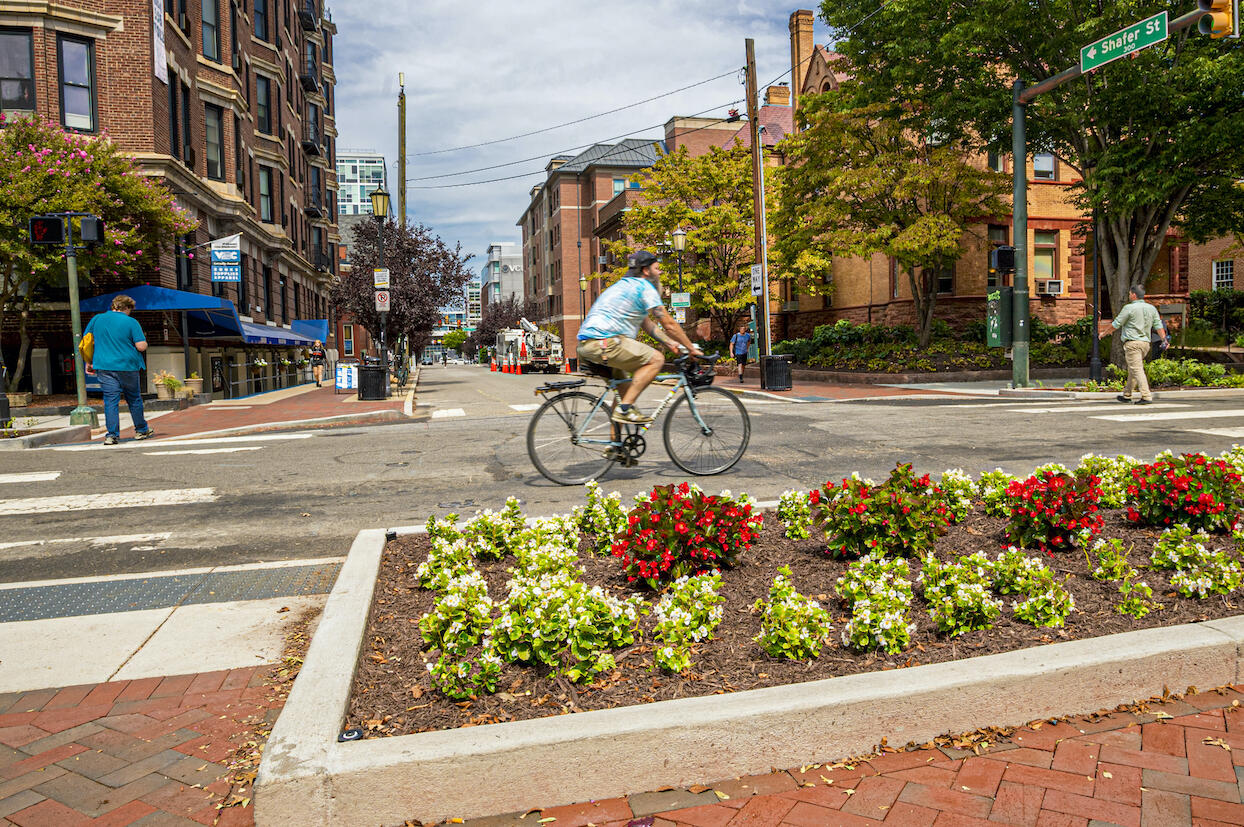 A bicyclist on a street travels through an intersection.