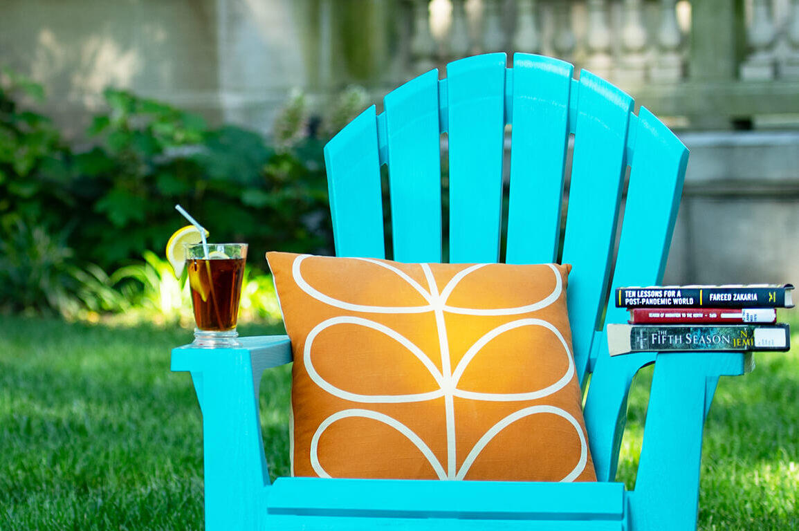 blue deck chair with books stacked on the armrest