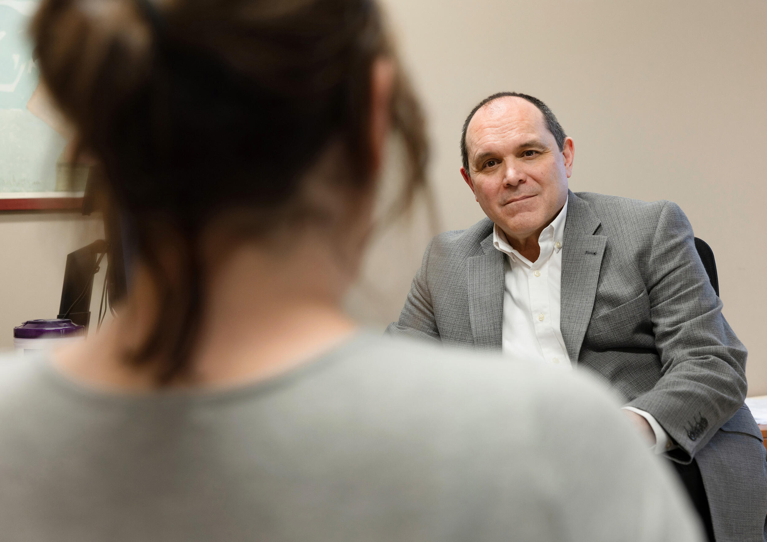 A photo of a man and woman sitting in a room across from each other. 