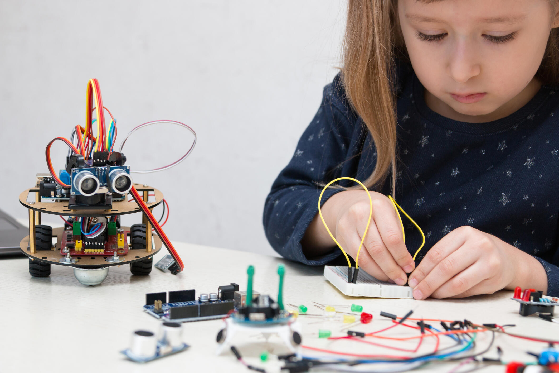A child playing with an electronic kit.