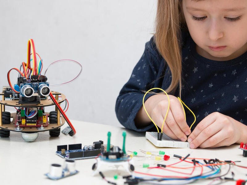 A child playing with an electronic kit.
