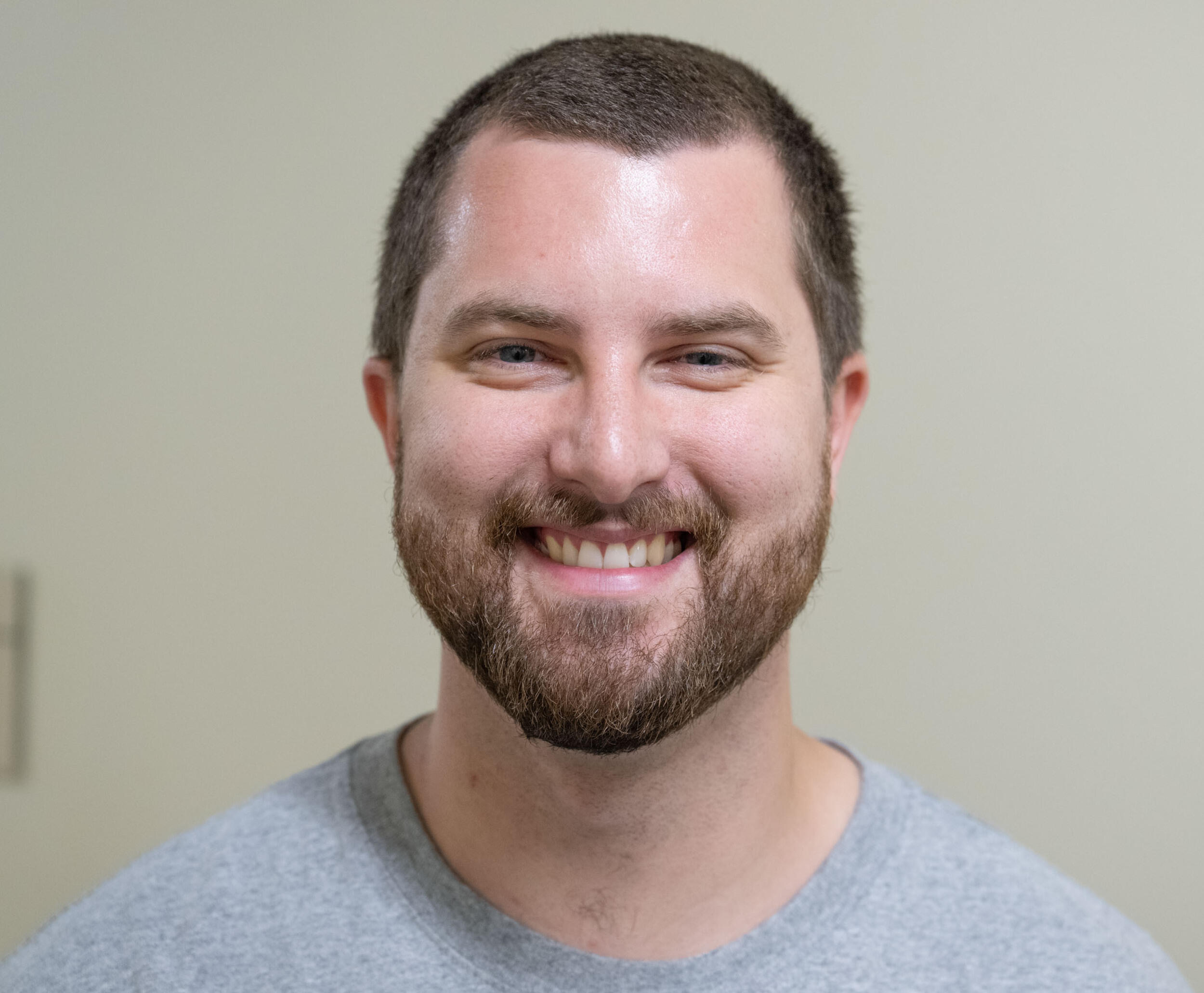 A photo of a man from the shoulders up. He is smiling. 