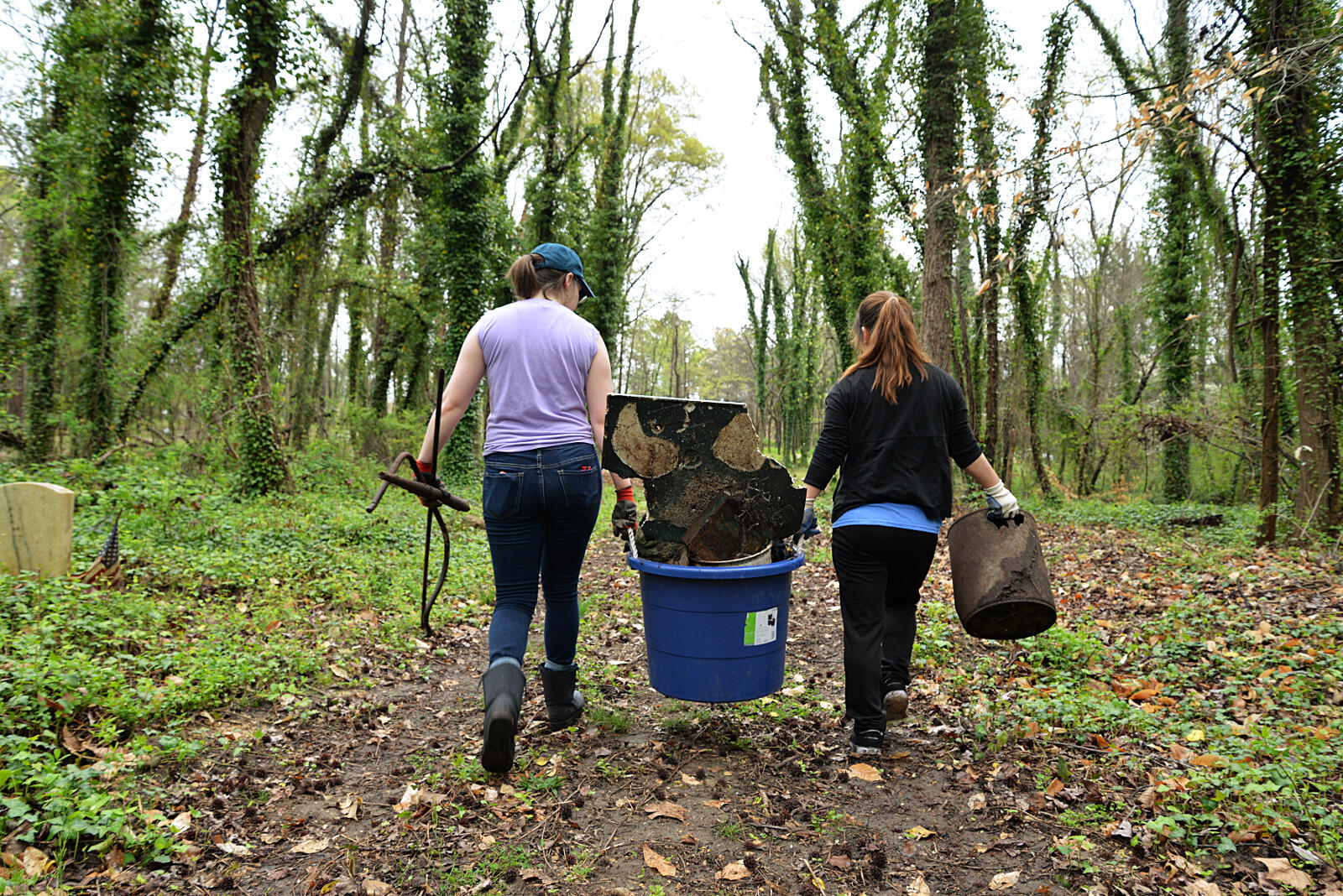 Angela Nam, a senior science major, and Madison Price, a junior sociology major, haul trash out of East End Cemetery.