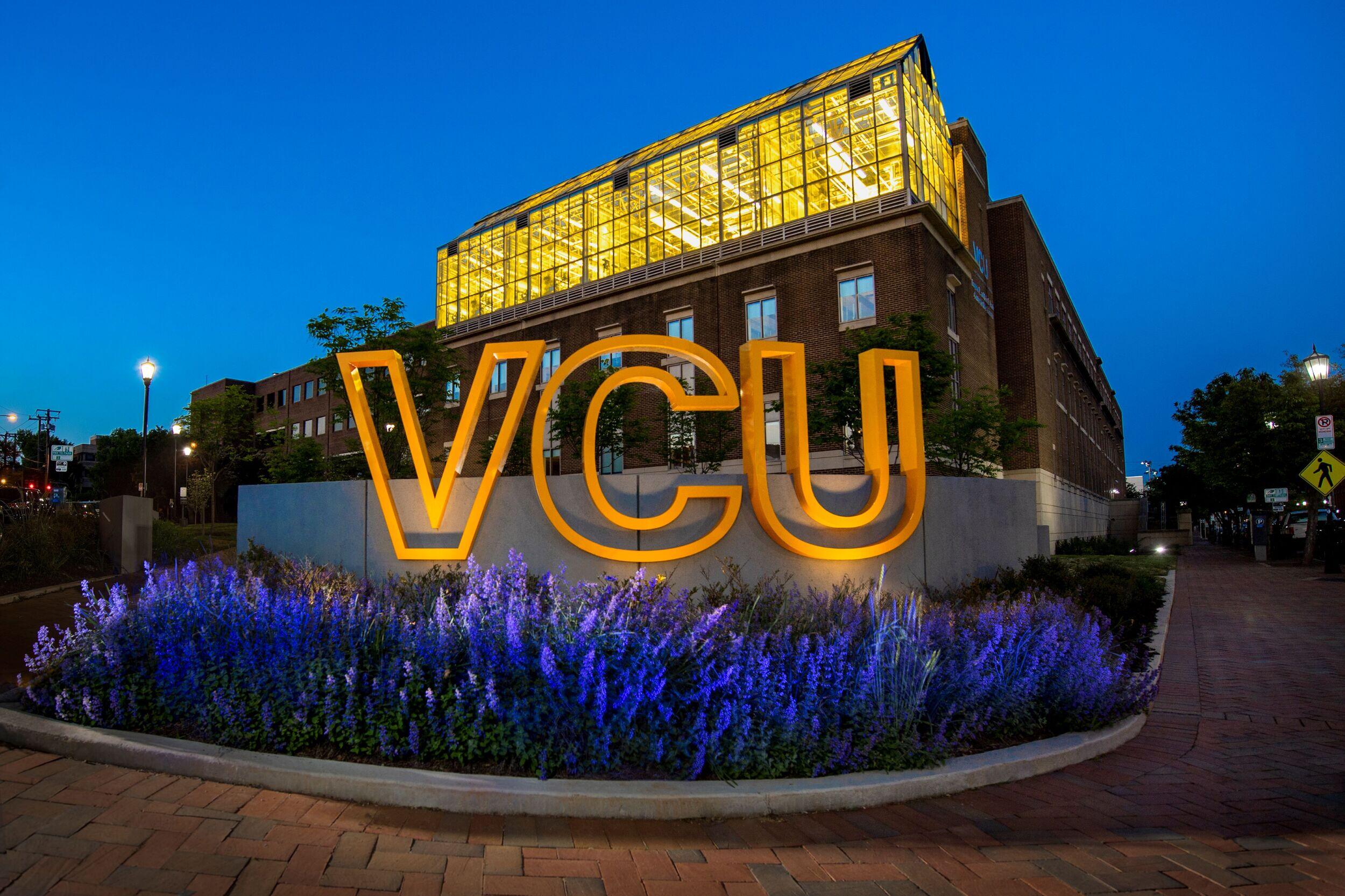 Lights shine on a gold VCU sign.