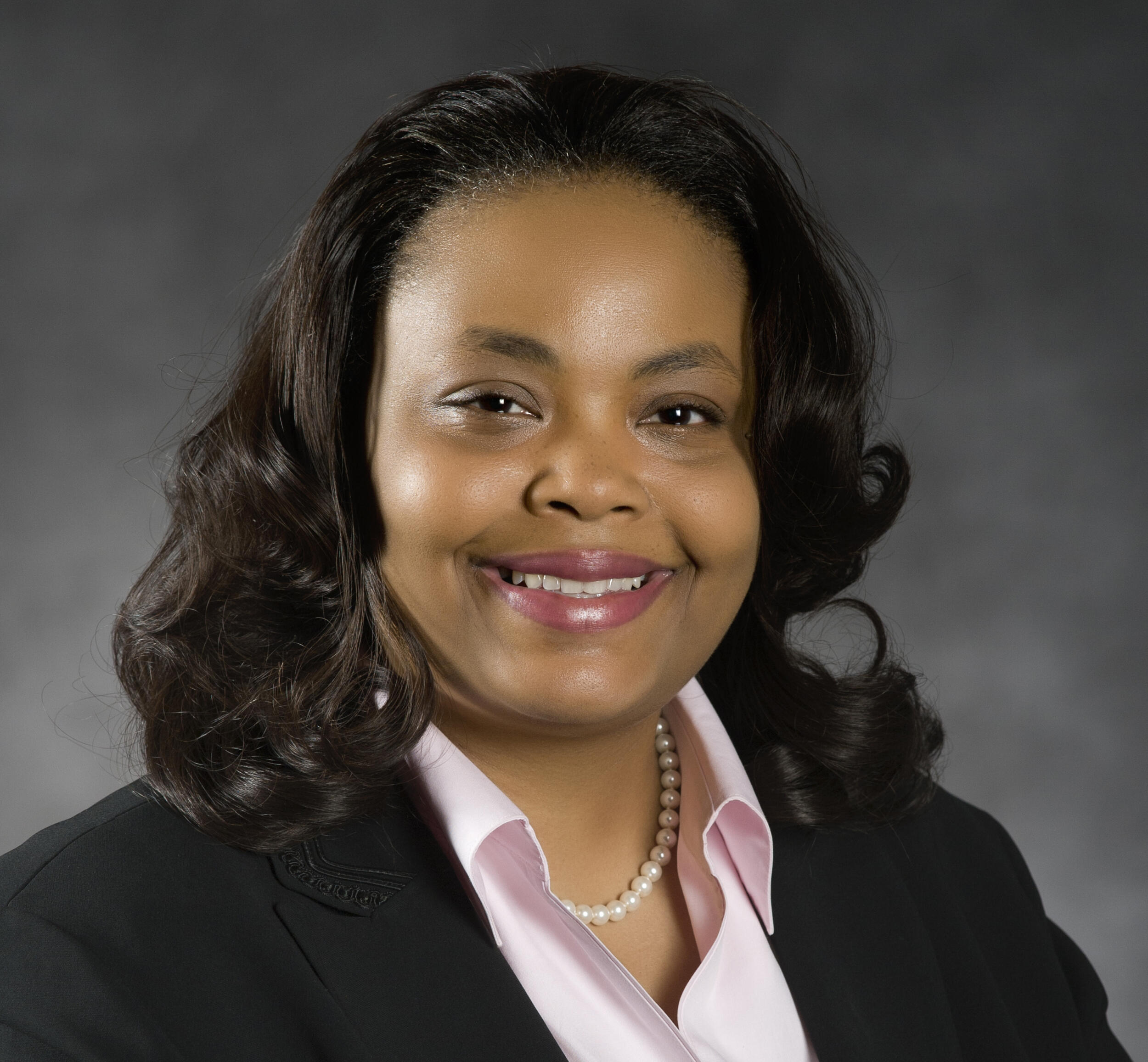A headshot portrait of a woman smiling.