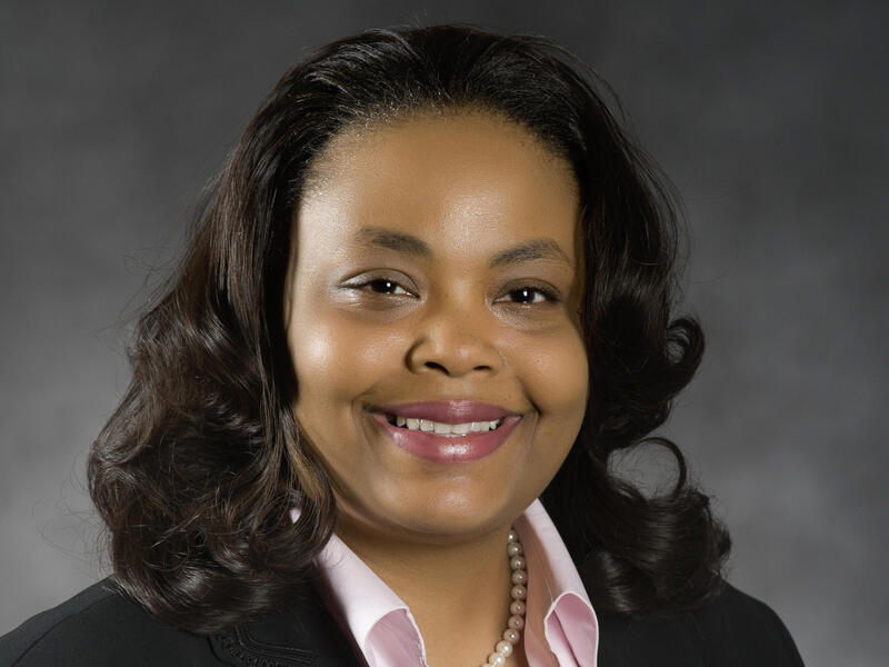 A headshot portrait of a woman smiling.
