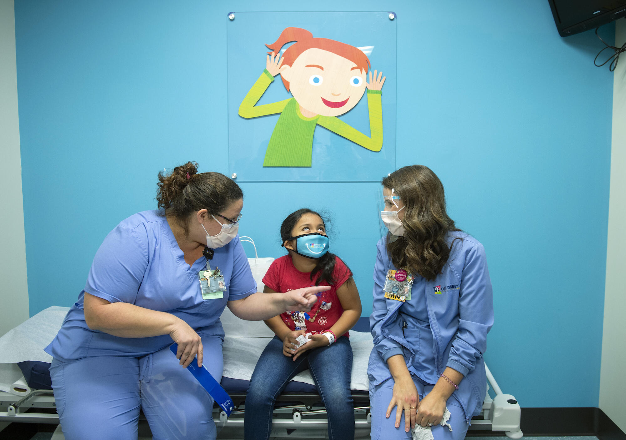 Mary Picado, center, speaks with team members at Children's Hospital of Richmond at VCU prior to receiving her COVID-19 vaccine. 
