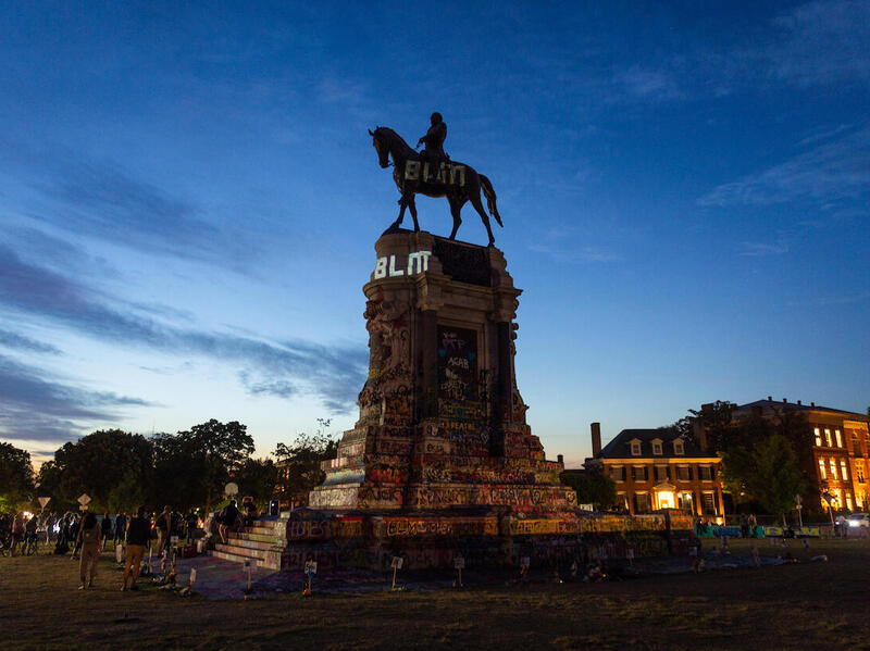 Lee Monument in Richmond with the letters \"B\" \"L\" and \"M\" projected onto it.