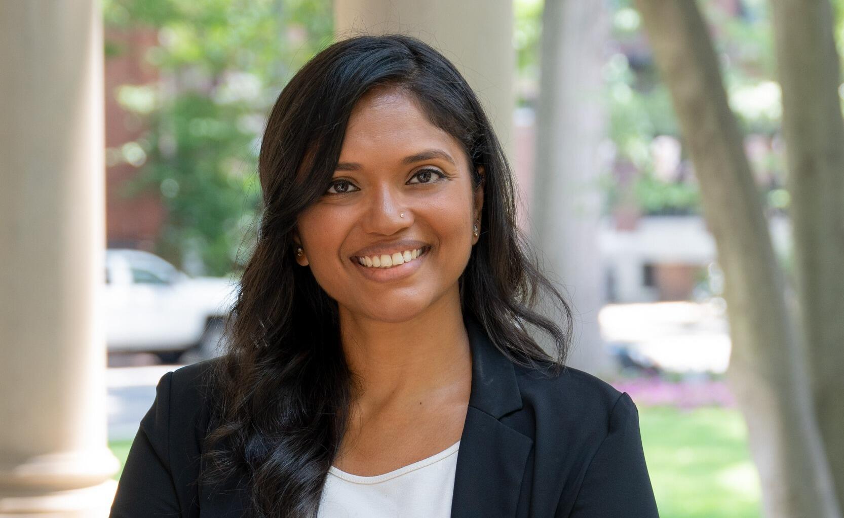 A woman standing and smiling with her arms across her chest 