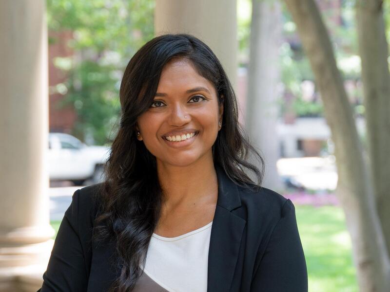A woman standing and smiling with her arms across her chest 