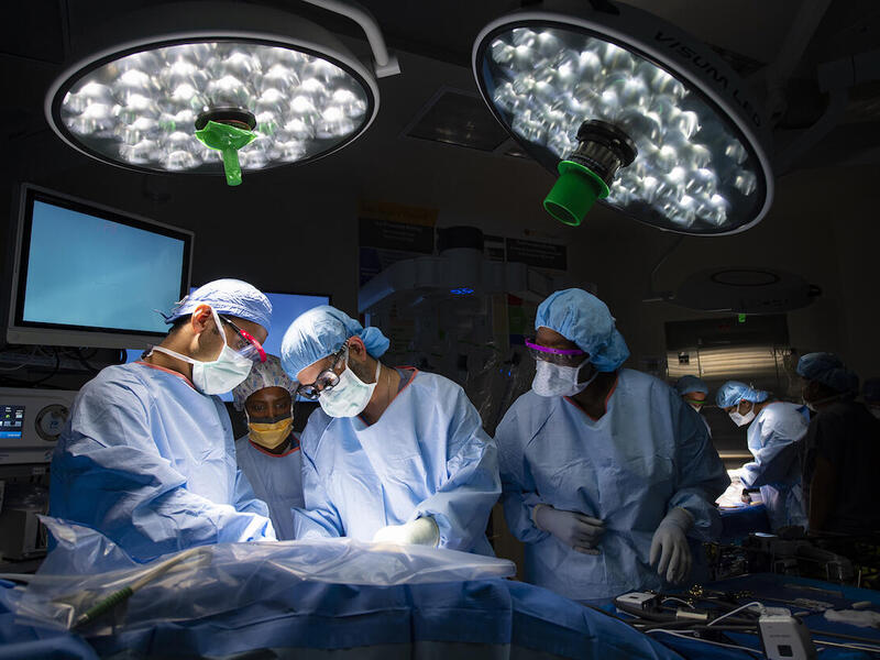 A group of doctors in an operating room performing surgery on a patient.