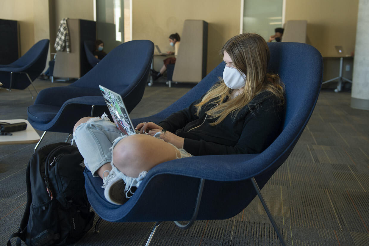A student sits in a chair at Cabell Library.