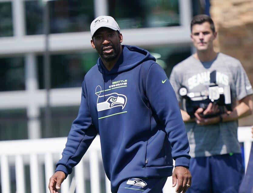 Aaron Curry walking on a field with a man behindhim 