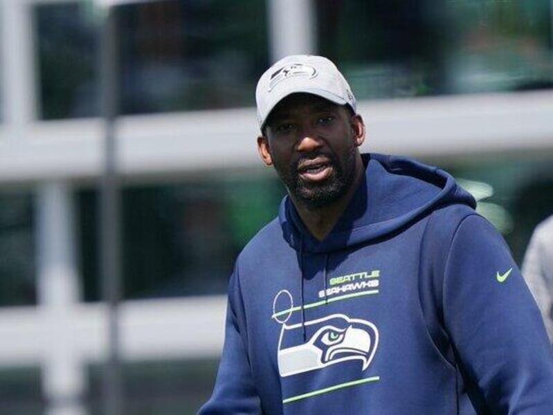 Aaron Curry walking on a field with a man behindhim 