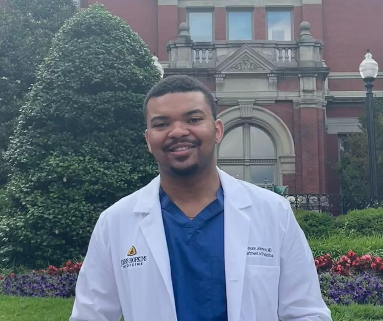 A photo of a man in a white lab coat from the chest up.