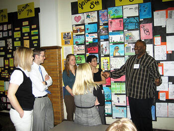 Joseph Norman talking with preservice teachers at the exhibit of student works.
